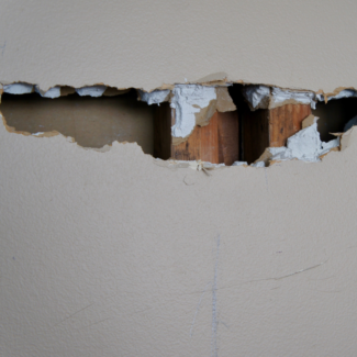 a hole in the wall exposed beams